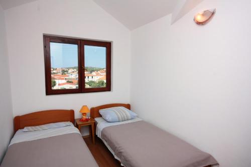 two beds in a room with a window at Apartments with parking space Jezera, Murter - 5109 in Jezera