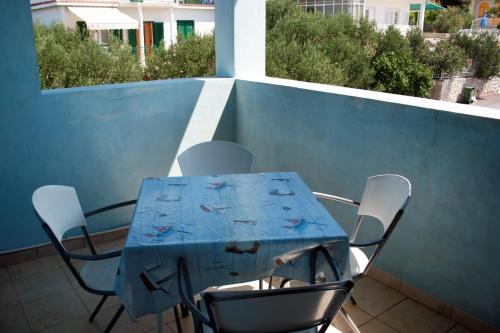 a blue table and chairs on a balcony at Apartments by the sea Jezera, Murter - 5063 in Jezera