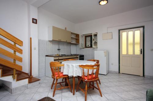 a kitchen with a table and chairs in a room at Seaside holiday house Murter - 5092 in Murter