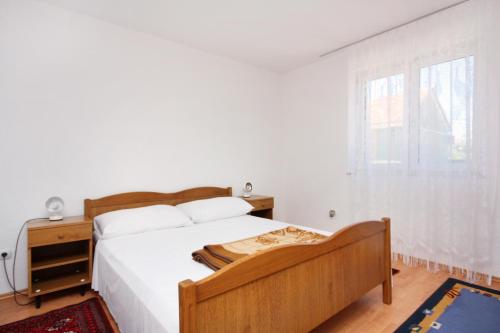 a white bedroom with a bed and a window at Apartments with parking space Murter - 5084 in Murter