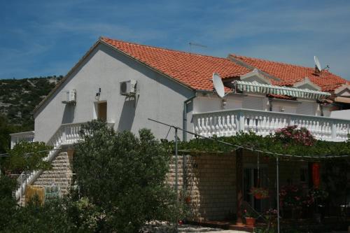 une maison blanche avec un toit rouge dans l'établissement Apartments and rooms with parking space Jezera, Murter - 5082, à Jezera