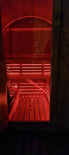 a wooden bench in a room with red lighting at Quinta Rico in Quatro Ribeiras