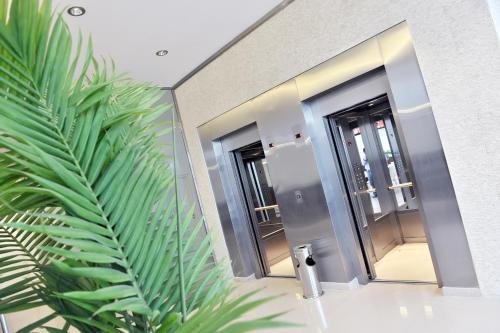 ein Badezimmer mit zwei Spiegeln und einer grünen Pflanze in der Unterkunft Luxor Hotel & Spa in Salta