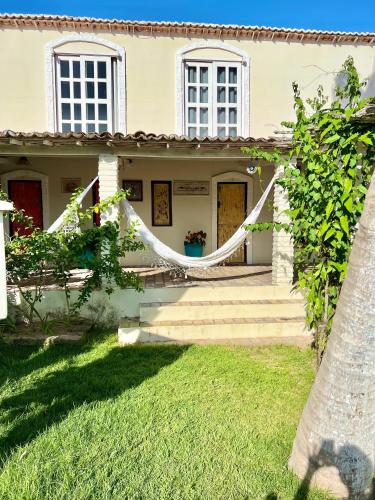 a white house with a porch and a yard at Pousada da Renata in Jericoacoara