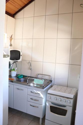 サン・トメー・ダス・レトラスにあるChalés Excaliburのシンクとコンロのある小さなキッチン
