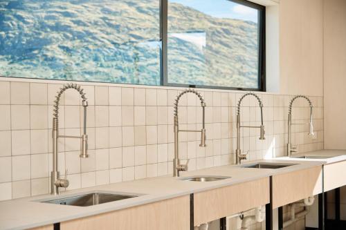 a kitchen with two sinks and a window at Driftaway Queenstown in Queenstown
