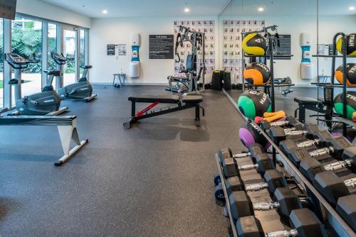 a gym with tread machines and a table and chairs at Chic Inner City Position 2 bedroom apartment with Parking By Serain Residences in Brisbane