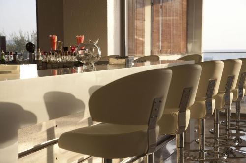 a row of chairs at a bar with a counter at Port Royal Villas and Spa - Adults Only in Kolimbia
