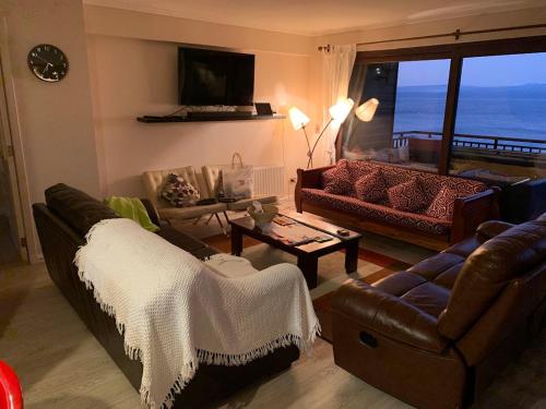 a living room with couches and a view of the ocean at Departamento en Condominio La Puntilla Villarrica in Villarrica