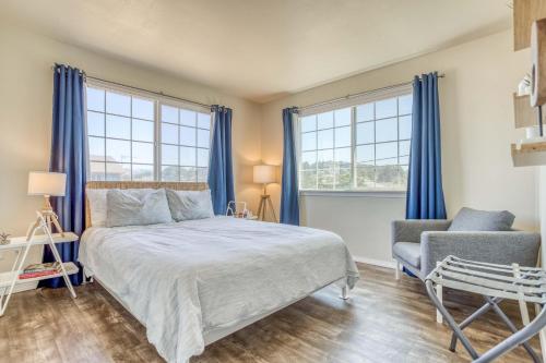 1 dormitorio con 1 cama, 1 silla y ventanas en Beachlandia, en Lincoln City