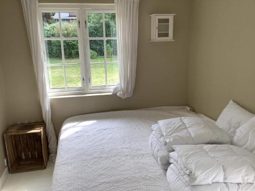 een slaapkamer met een wit bed en een raam bij Holiday home Gilleleje LXXXVIII in Gilleleje