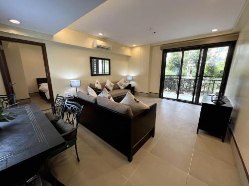uma sala de estar com um sofá e uma mesa em Anvaya Cove Short Term Rental Condos em Morong