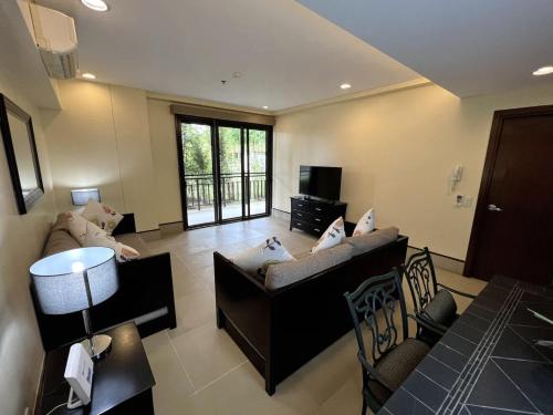 Sala de estar con 2 sofás y TV en Anvaya Cove Short Term Rental Condos en Morong