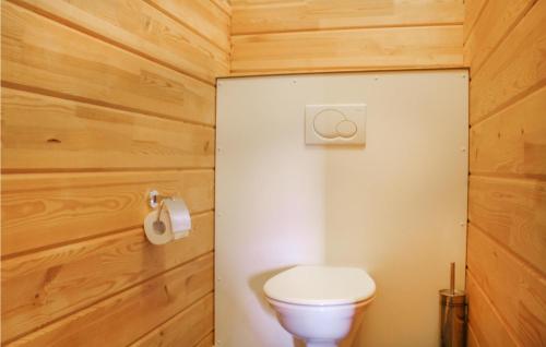a bathroom with a toilet and a wooden wall at Stunning Home In Heel With Lake View in Heel