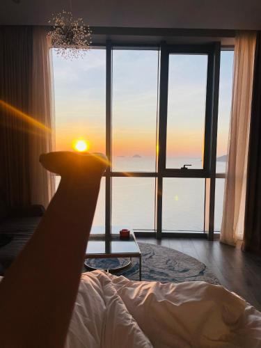 a room with a bed with a view of the ocean at PANORAMA Condotel by HLG in Nha Trang