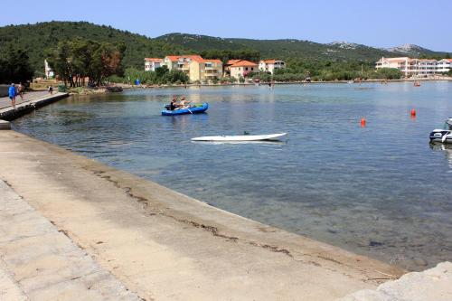 a couple of people in a boat in the water at Apartments with parking space Pasman - 8214 in Pašman
