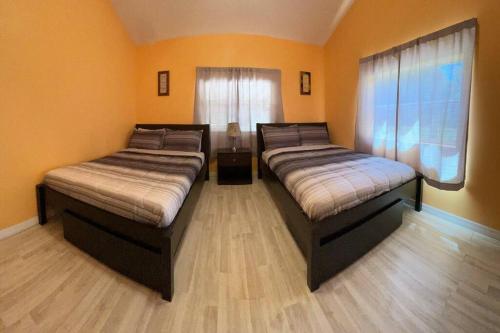 two beds are in a room with wood floors at The Piano House in Orlando