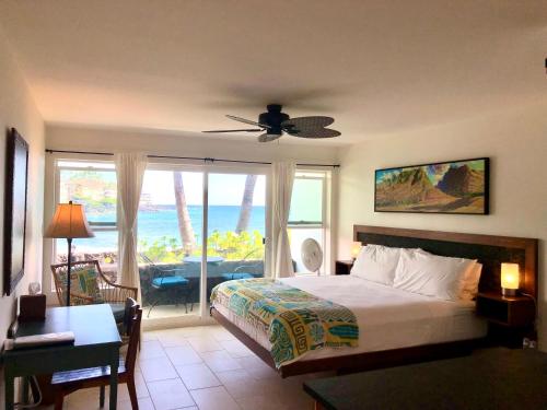 een slaapkamer met een bed en uitzicht op de oceaan bij Kona Tiki Hotel in Kailua-Kona