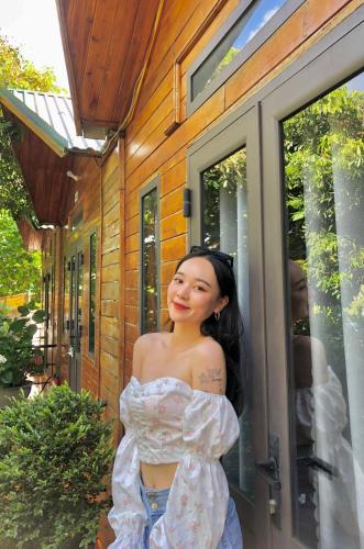 a woman is standing outside of a house at Cô Tô Homestay 368 in Chung Cap
