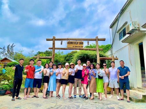 a group of people posing for a picture in front of a sign at Cô Tô Homestay 368 in Chung Cap