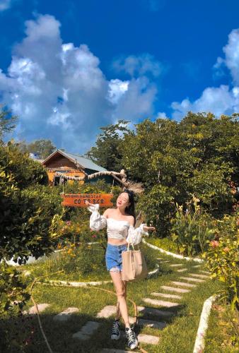 a woman standing on a path in a garden at Cô Tô Homestay 368 in Chung Cap