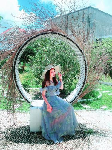 a woman in a blue dress sitting in front of a mirror at Cô Tô Homestay 368 in Chung Cap