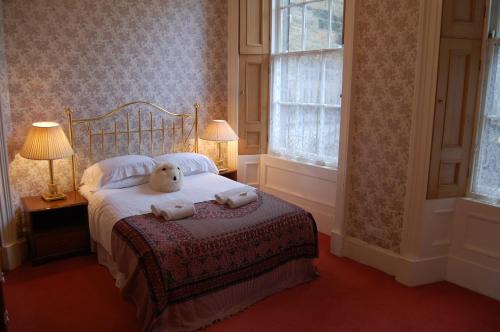 a bedroom with a bed with a teddy bear on it at Central Regent Terrace Apartment in Edinburgh