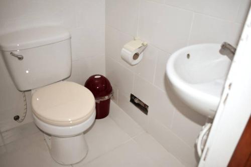 La salle de bains blanche est pourvue de toilettes et d'un lavabo. dans l'établissement Departamento - Los Mitos del Parque M2, à Chiclayo