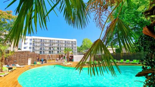 uma grande piscina com um hotel ao fundo em Mojo Resort em Eforie Sud