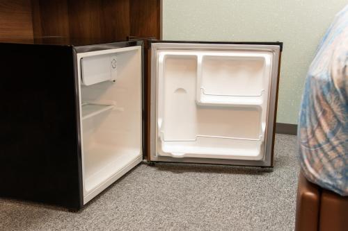 an empty refrigerator with its door open in a room at Yokohama Sakuragicho Town Hotel in Yokohama