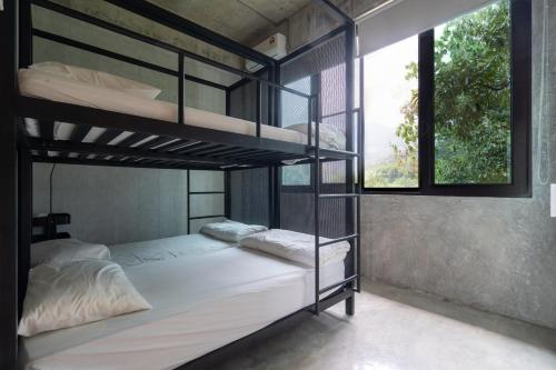 a bedroom with two bunk beds and a window at Brickhouse Bukit Tinggi by Santai Villas in Bentong