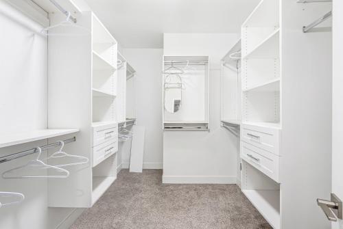 a white walk in closet with white cabinets at T&T Lodge in Surrey