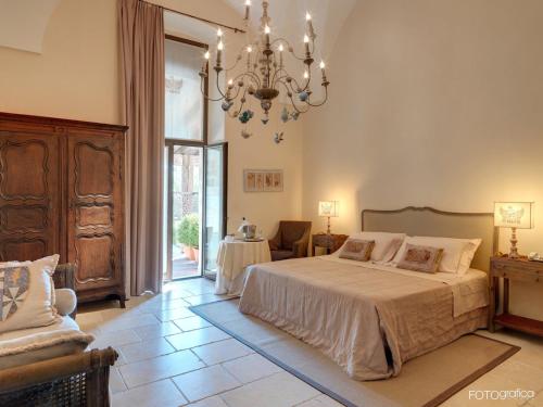 Schlafzimmer mit einem Bett und einem Kronleuchter in der Unterkunft Dimora Storica Torre Del Parco 1419 in Lecce