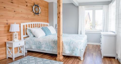 a bedroom with a bed and a wooden wall at Main Street Downtown Apartments in Bar Harbor