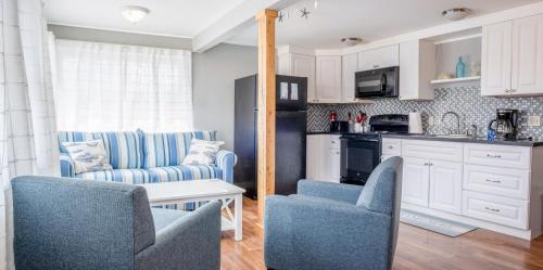 a living room with two chairs and a kitchen at Main Street Downtown Apartments in Bar Harbor