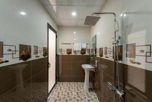 a bathroom with a shower and a sink and a toilet at Tan Dinh Farmstay in Ninh Binh