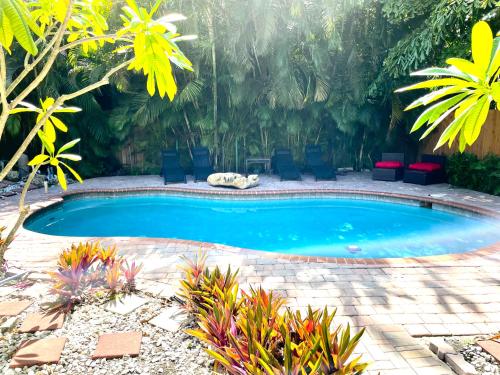 een zwembad in een tuin met stoelen en planten bij Victoria Park Home, Private Pool 2miles from Beach in Fort Lauderdale