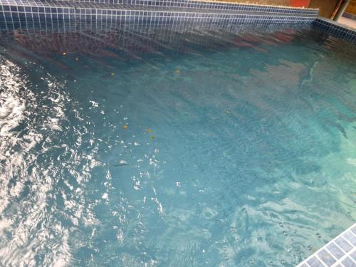 a swimming pool with blue water in a building at Hotel Raaj Inn in Calangute