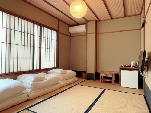 京都的住宿－羅馬館日式旅館，一间设有两张床和一台电视的房间