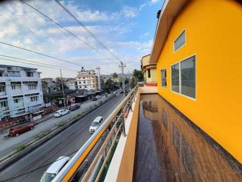a yellow building with a view of a street at The PALM SUITES , Incredible India Tourism in Guwahati