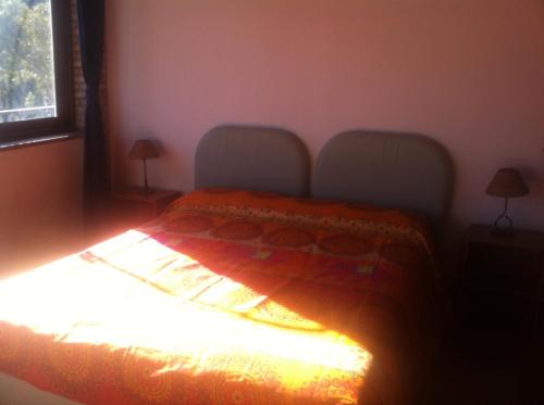 a bedroom with a bed with an orange blanket on it at ToviMar Apartments in Taormina