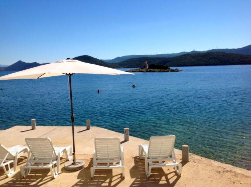 a group of chairs and an umbrella on a beach at Apartments Tamaris in Klek
