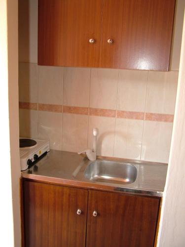 a small kitchen with a sink and a stove at George's Apartment in Agia Marina Aegina