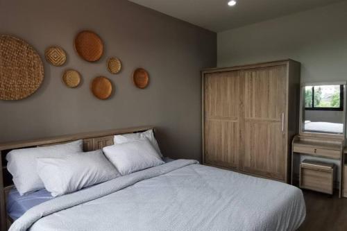 um quarto com uma cama com lençóis brancos e uma janela em 8FINITE House em Bang Su