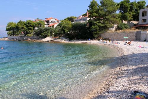 a group of people on a beach near the water at Apartments by the sea Splitska, Brac - 2865 in Postira