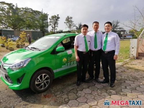 three men wearing ties standing next to a green car at Khách sạn NHẬT MINH Cửa Lò in Cửa Lò