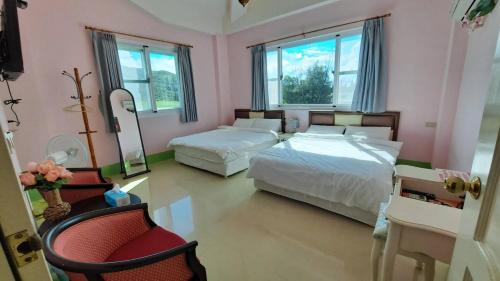 1 dormitorio con 2 camas, silla y espejo en 尖山沐氧 Jianshan Bathe Oxygen, en Kenting