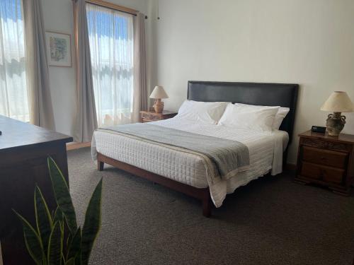 a bedroom with a bed with white sheets and pillows at Canyon Rose Suites in Bisbee