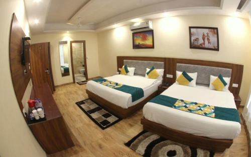 a hotel room with two beds and a mirror at The Royal Bhumesh in Katra