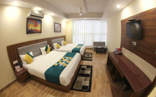 a bedroom with two beds and a flat screen tv at The Royal Bhumesh in Katra